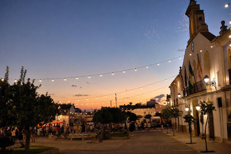 Festival lights over a Spanish town plaza at dusk